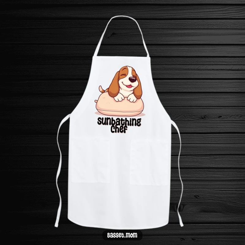 Funny Basset Hound apron showing a smiling dog sunbathing on a pillow, a humorous and practical accessory for kitchen use.