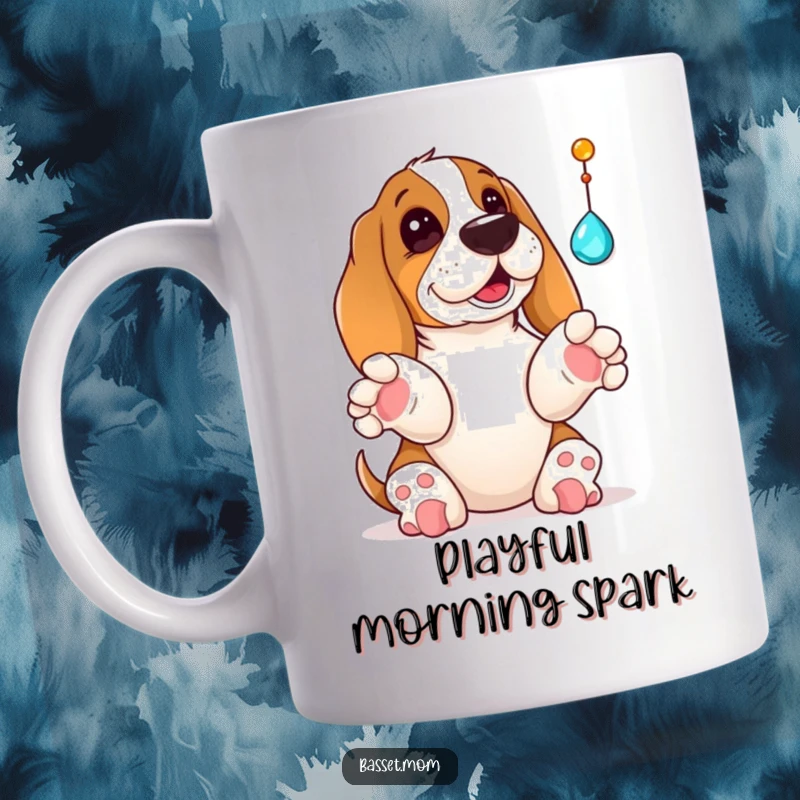Funny Basset Hound mug illustration of a dog with paws raised, comically batting at a dangling shiny jewel, showing intense playful focus.