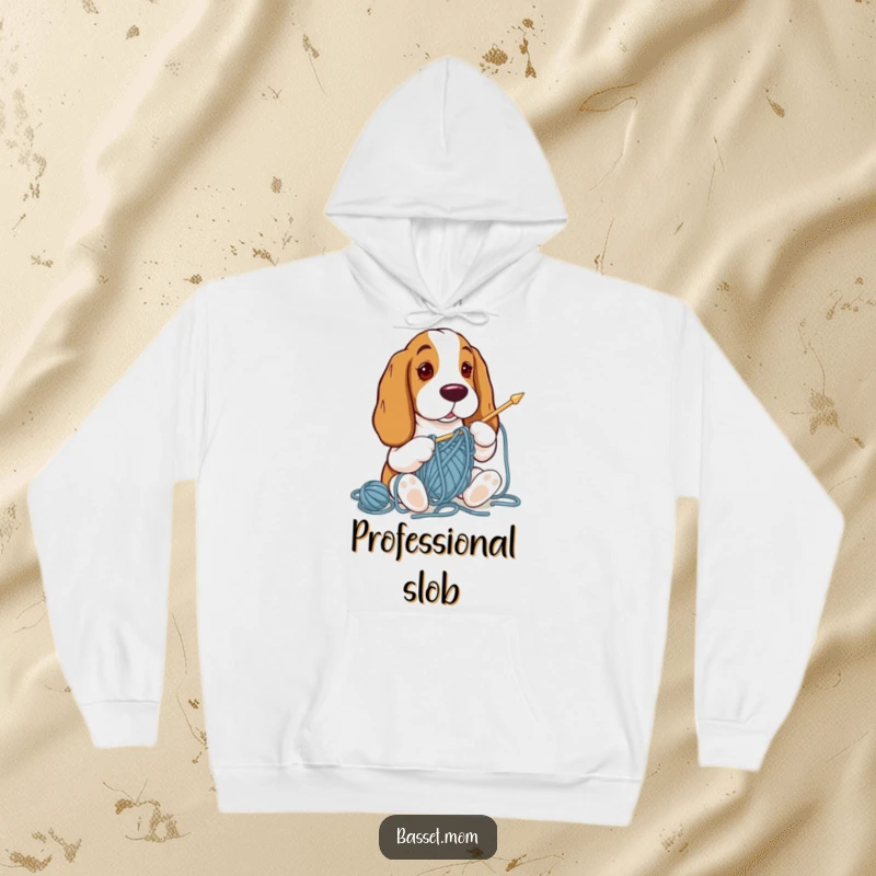 Funny Basset Hound tangled in yarn while attempting to knit, looking distressed on a warm, comfortable hoodie.