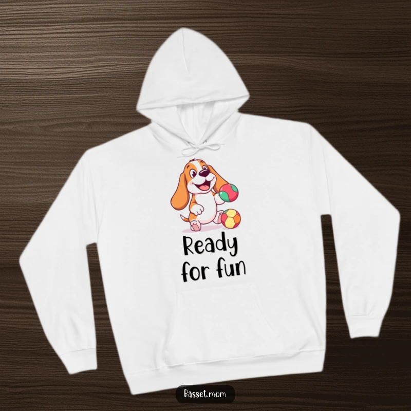 Funny Basset Hound hoodie, cheerful expression, actively bouncing a colorful ball, perfect for cozying up with a dose of doggy joy.