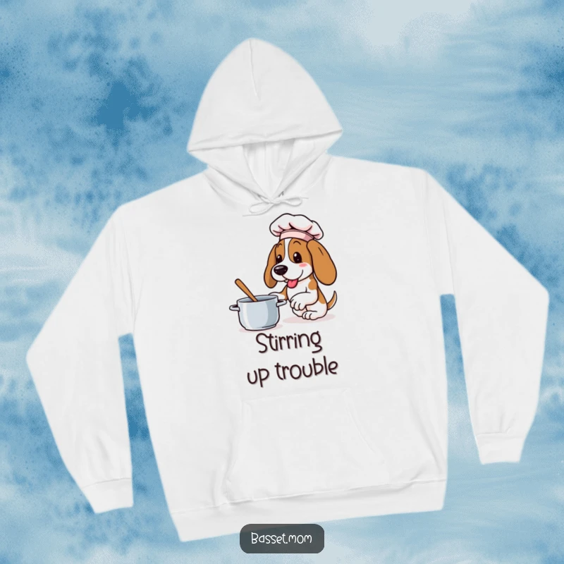 Funny Basset Hound hoodie of a dog in a tiny chef hat, enthusiastically stirring a pot, offering warmth and foodie fun.