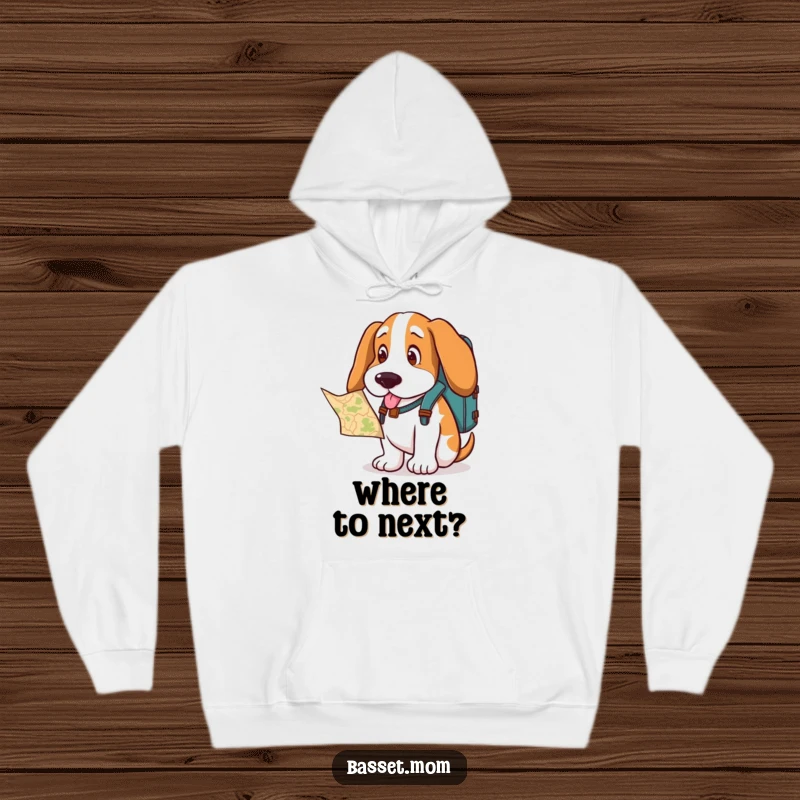 Funny Basset Hound hoodie, a dog with a backpack, looking curiously at a map, preparing for an epic journey.