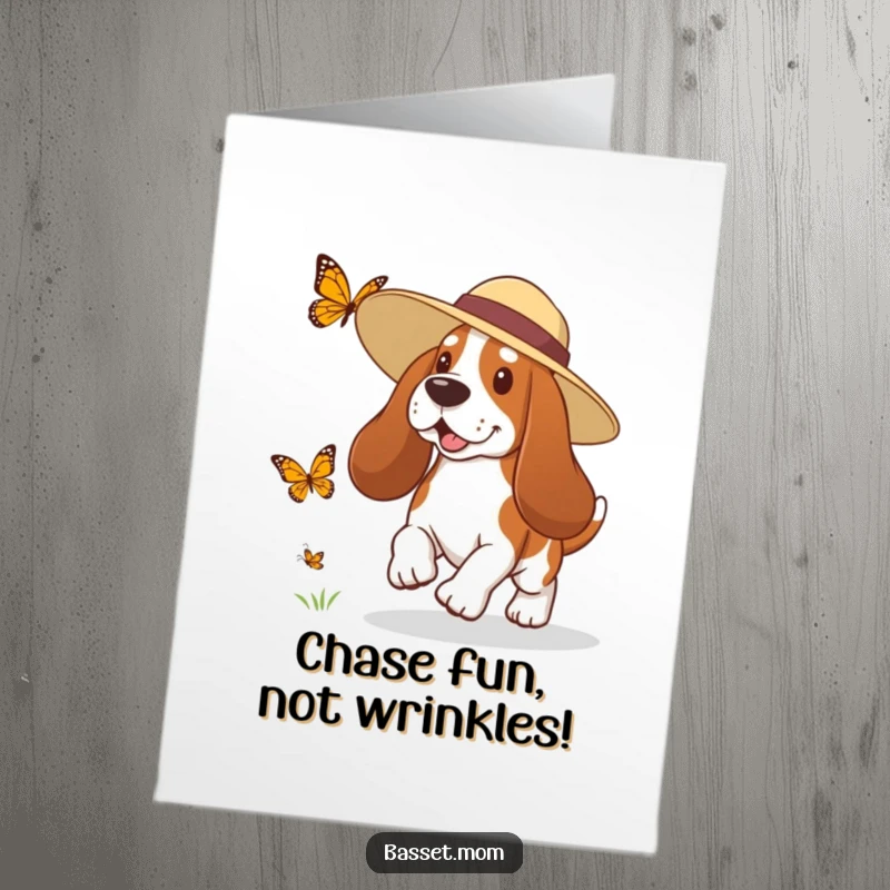 Funny Free Printable Birthday Card: A Basset Hound in a sun hat playfully chasing a butterfly in a sunny meadow.
