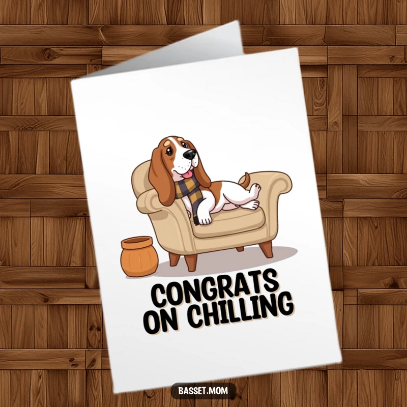 Funny Free Printable Congratulations Card: A Basset Hound in a scarf looks perfectly relaxed while lounging on a cozy armchair, celebrating.