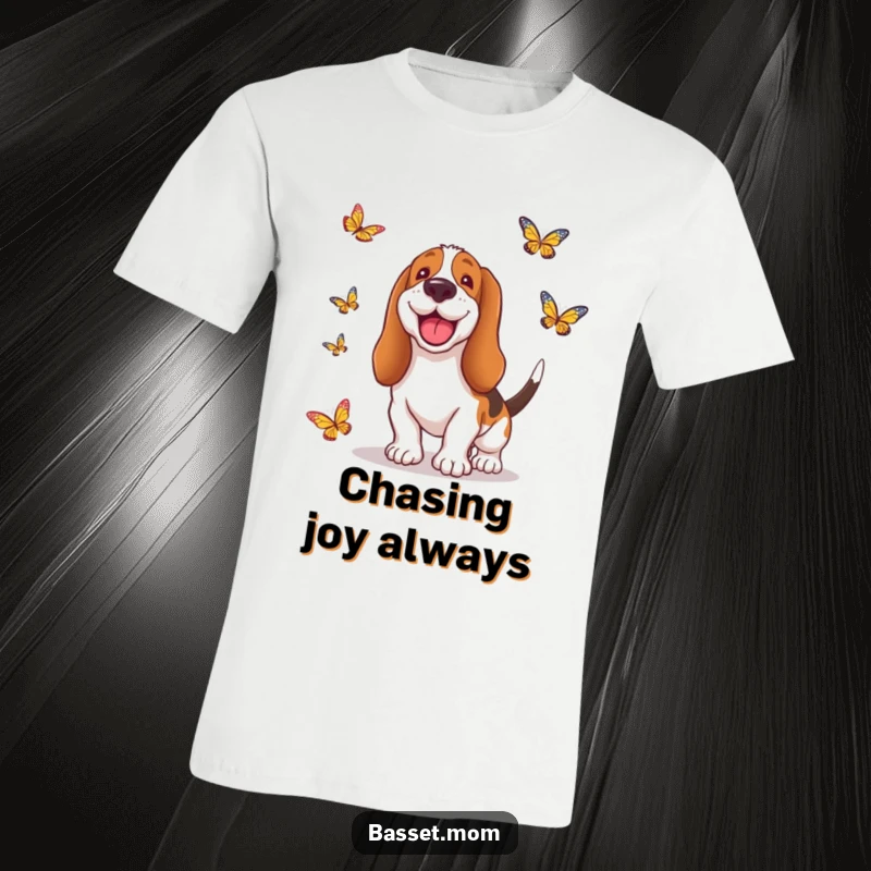 Funny Basset Hound t-shirt showing a smiling dog with its ears flopping, enthusiastically chasing after colorful butterflies in a whimsical scene.
