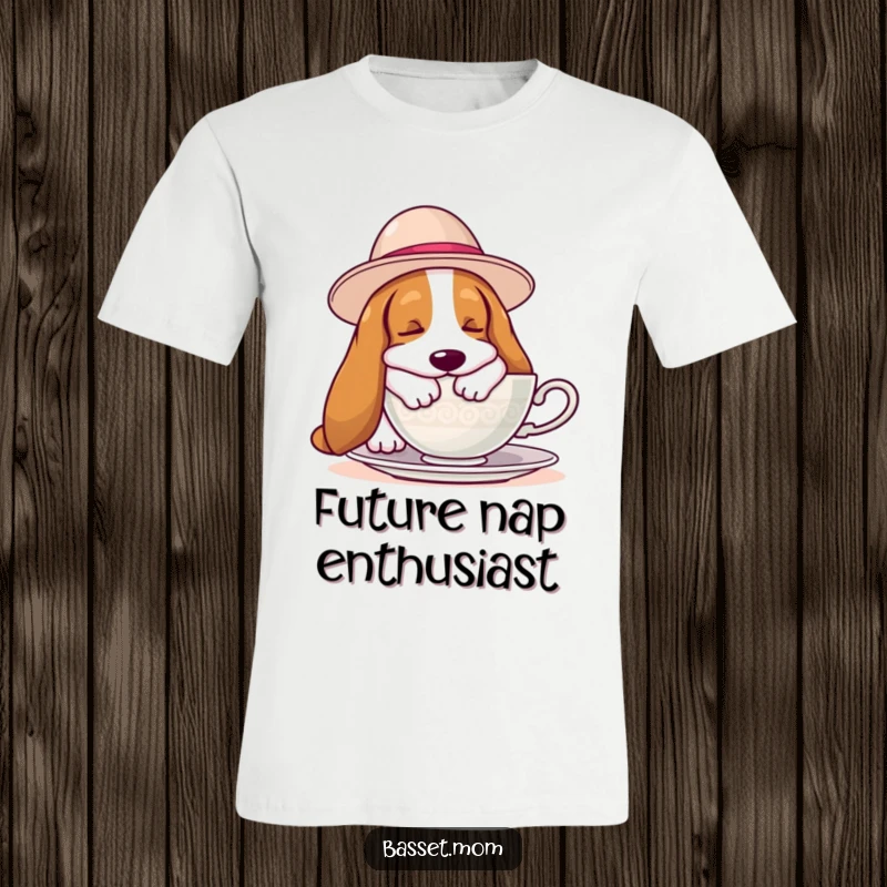 Funny Basset Hound t-shirt with a hound wearing a big hat, fast asleep next to a teacup, perfect for lazy day enthusiasts.
